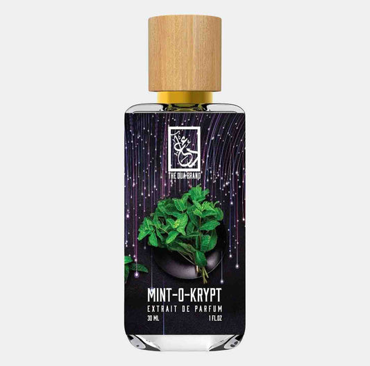 Flesje van Dua Mint O Krypt, een 30 ml extrait de parfum, met een stijlvolle houten dop en een achtergrond van groene muntbladeren.