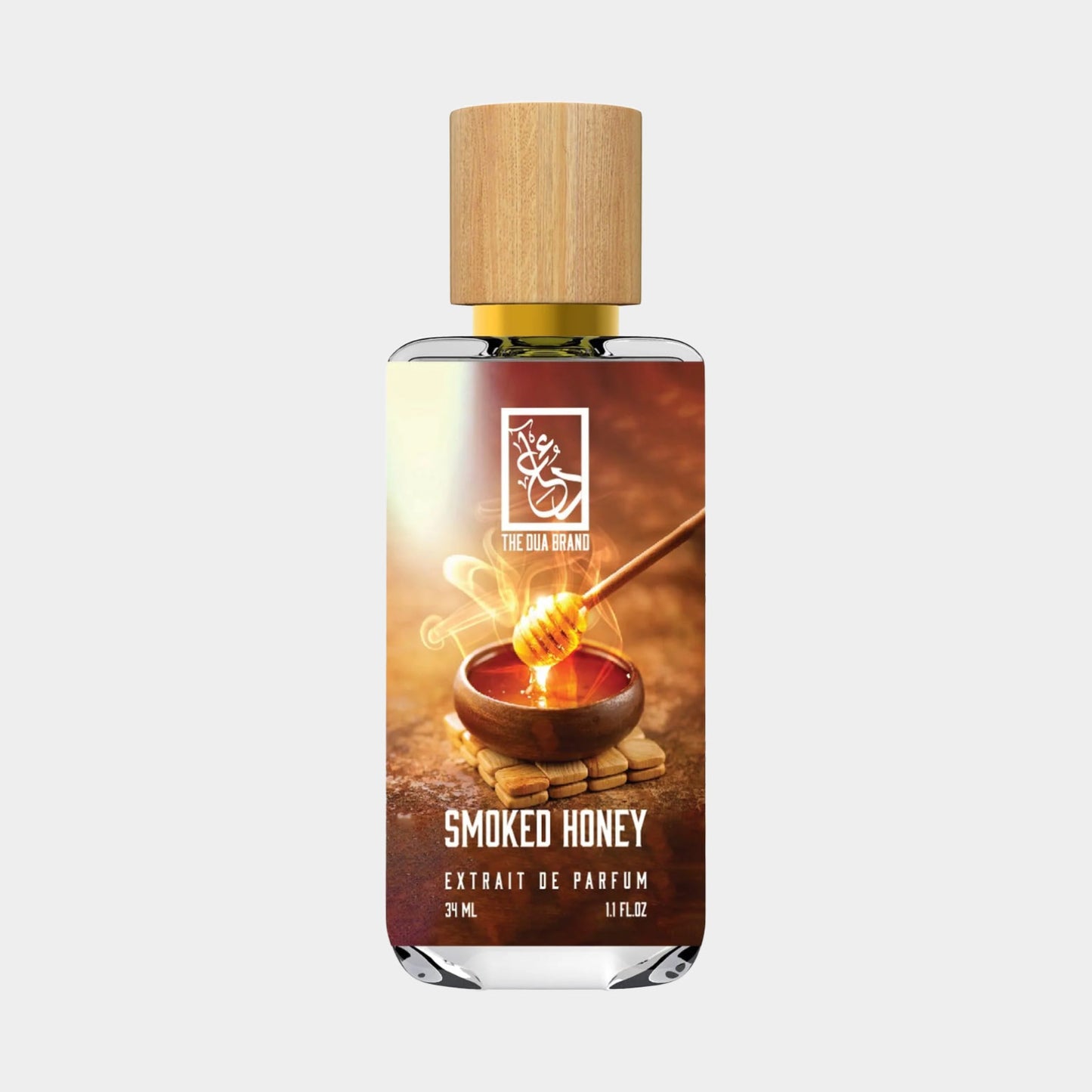 Een flesje Dua Smoked Honey Sample parfum van 3 ml met een houten dop, afgebeeld met een honingpot en honinglepel. De verpakking straalt een warme, rokerige geur uit.