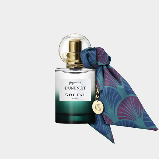 Goutal Étoile dUne Nuit parfum met een elegante flacon, versierd met een kleurrijke sjaal en een gouden dop. De fles heeft een verfijnde groene gradatie.