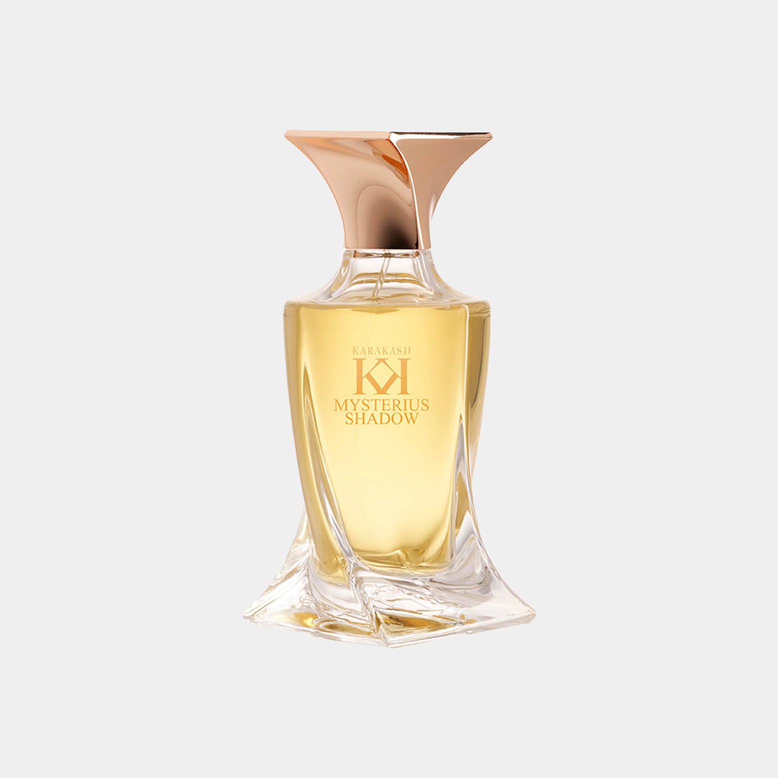 Een elegant parfumflesje van Karakash met de naam Mysterious Shadow, gekenmerkt door een unieke vorm en een gouden dop. De vloeistof heeft een warme, amberkleurige tint.