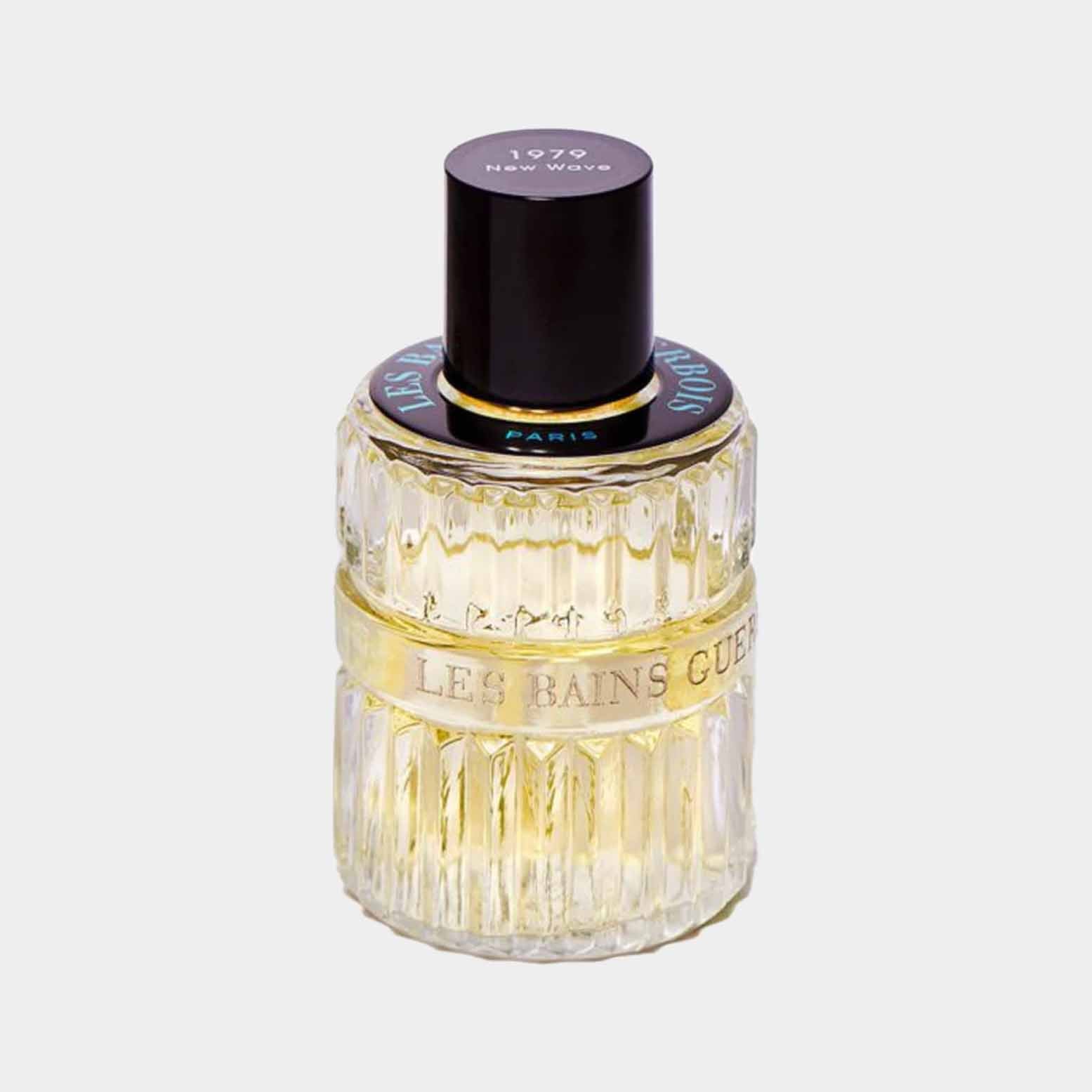 Een transparante geurflacon van Les Bains Guerbois New Wave 1979, versierd met een gouden band en een zwarte dop, die het luxe en retro ontwerp van de parfum benadrukt.