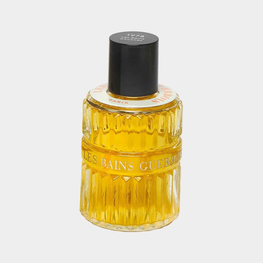 Les Bains Guerbois Douches 1978 Sample in een stijlvolle, gestructureerde fles met een zwarte dop en heldergele parfum.