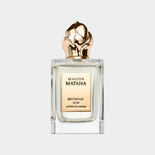 Maison Mataha Brownie Pop Sample, een elegant parfumbottle met een gouden bloemtop en een luxe uitstraling.