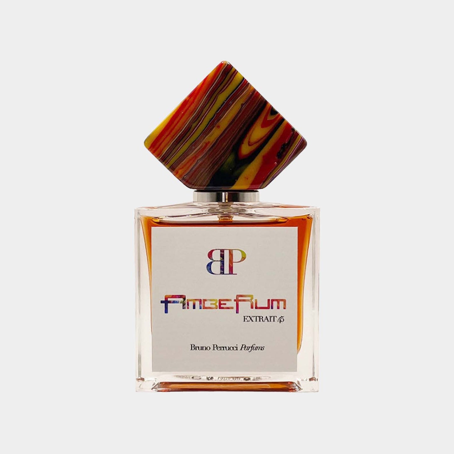Een elegantere geurflacon van Bruno Perrucci met een kleurrijke, opvallende dop, met de labeltekst AmbeRum Sample.