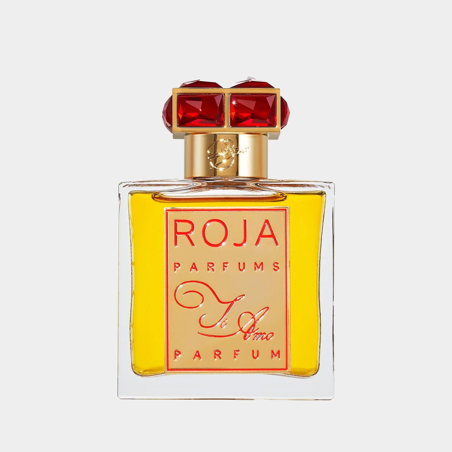 Een luxueuze parfumfles van Roja Dove Ti Amo, met een elegante, gouden vloeistof en opvallende rode edelstenen op de dop. De verfijnde verpakking straalt een gevoel van romantiek en exclusiviteit uit.