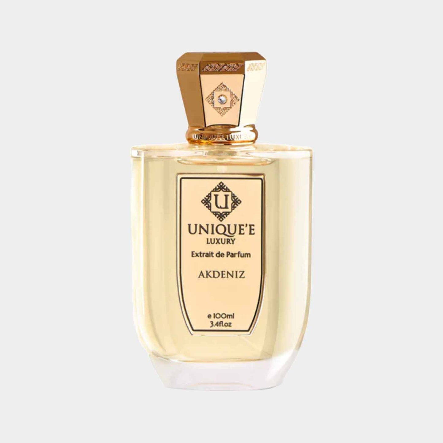 Een elegante fles van Uniquee Luxury Akdeniz Sample, gevuld met een lichte parfum, presenteert een luxe uitstraling met een gouden dop en gedetailleerd label.