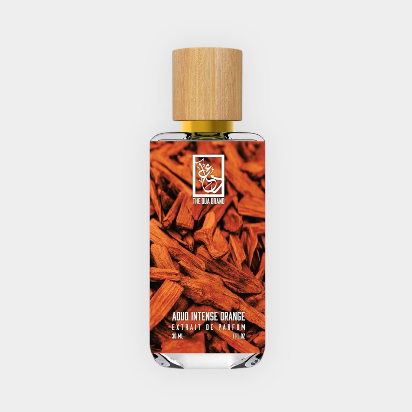 Dua Aoud Intense Orange sample in een elegante glazen flacon met houten dop, omringd door stukken sandelhout. Dit parfum biedt een rijke, intense geurervaring.